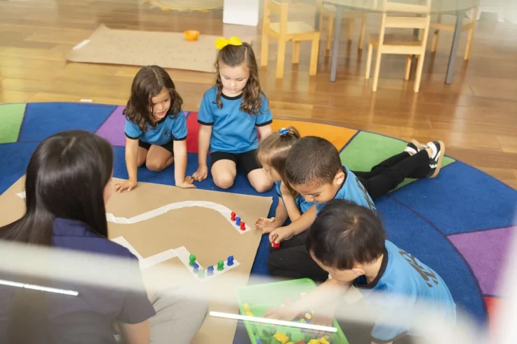 MBS early childhood students with their teacher working on a classroom activity