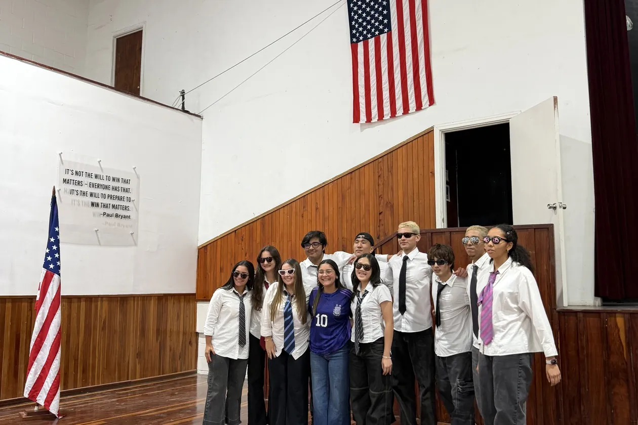 MBS students gathered under the American flag in the school auditorium