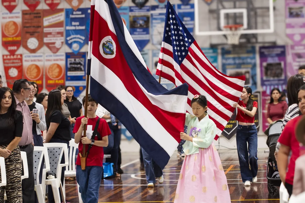 MBS students carrying Costa Rican and U.S. flags at a school civic event