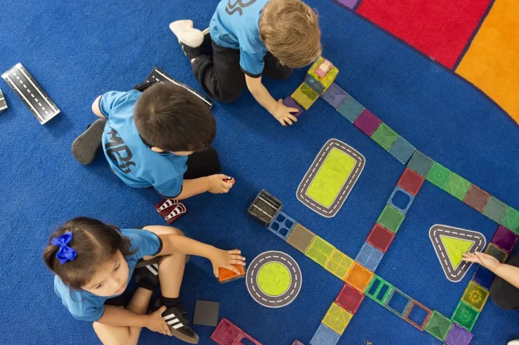 MBS early childhood students playing on a colorful floor game