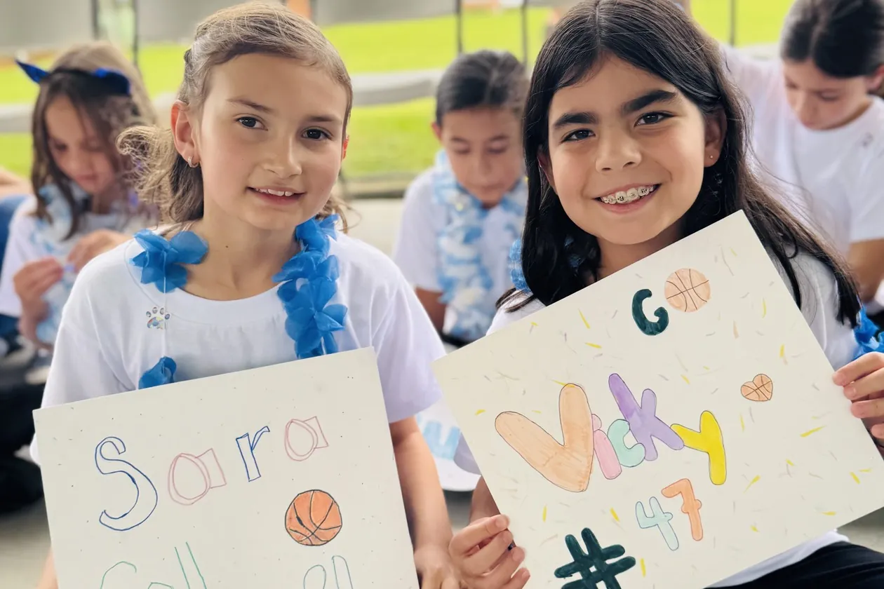 MBS students cheering with handmade signs for their classmates